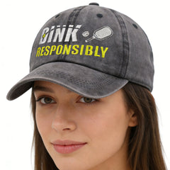 Gray cap with 'Drink Responsibly' text and pickleball paddle graphic worn by a model